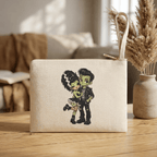 Frankie & Frannie Accessory Pouch in natural canvas, standing upright on a wood table with decor