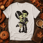 Frankie & Frannie Premium T-Shirt in vintage white, flat lay with chibi Frankenstein couple graphic and fall props