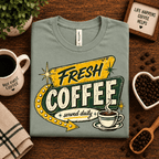 Fresh Coffee Premium T-Shirt in sage, folded close-up styled with coffee beans and a mug