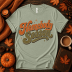 Homebody Season Premium T-Shirt in sage, flat lay with autumn props