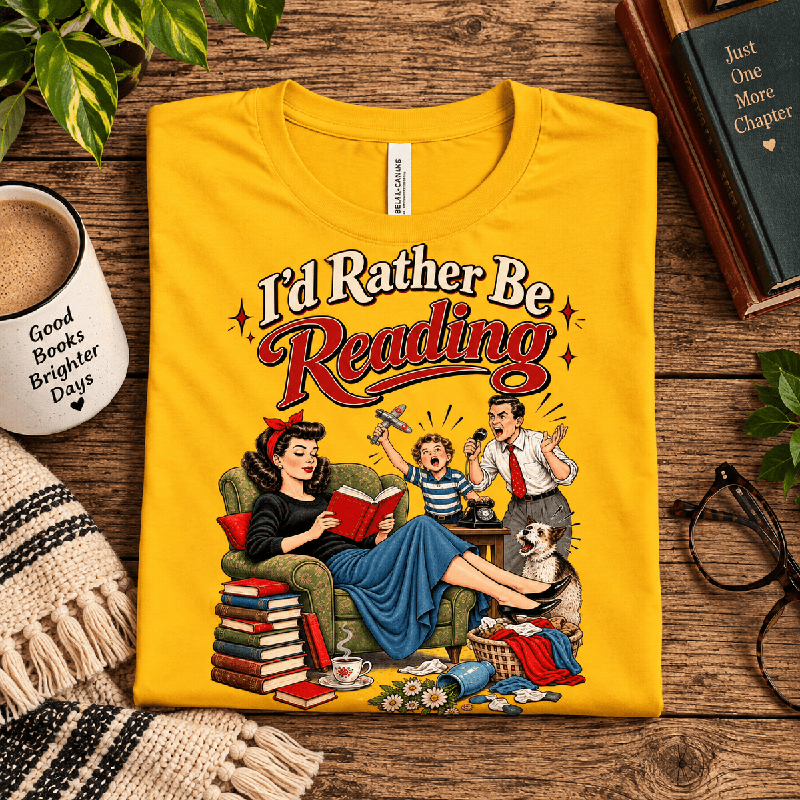 I'd Rather Be Premium T-Shirt in gold, folded close-up styled with a book and glasses