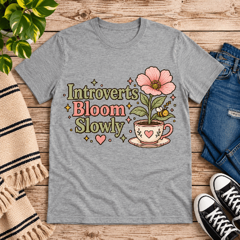 Introverts Bloom Slowly Premium T-Shirt in athletic heather gray, flat lay with flower-in-teacup and bee graphic