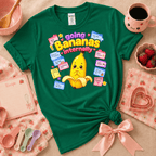 Going Bananas kawaii cute fruit graphic t-shirt displayed in a cozy flat lay in kelly green.