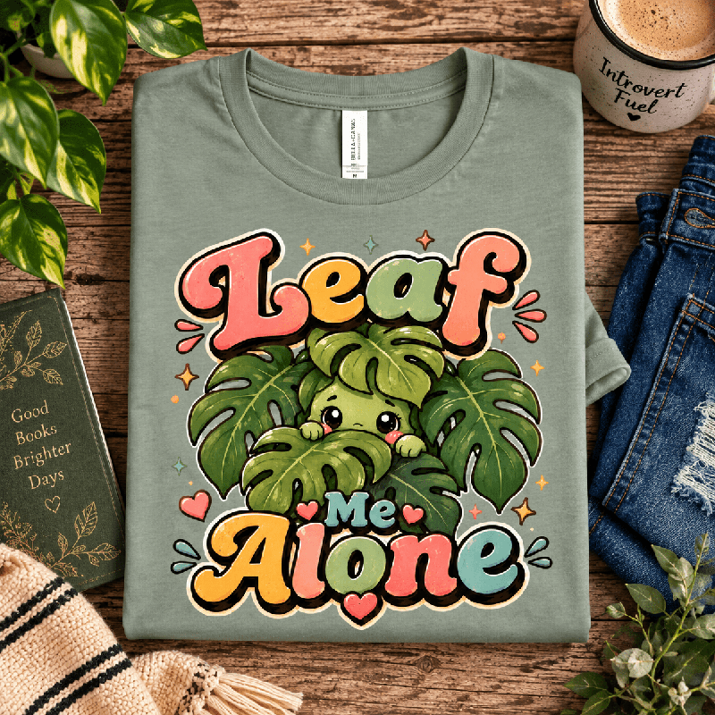 Leaf Me Alone Premium T-Shirt in sage, folded close-up with neck tag showing
