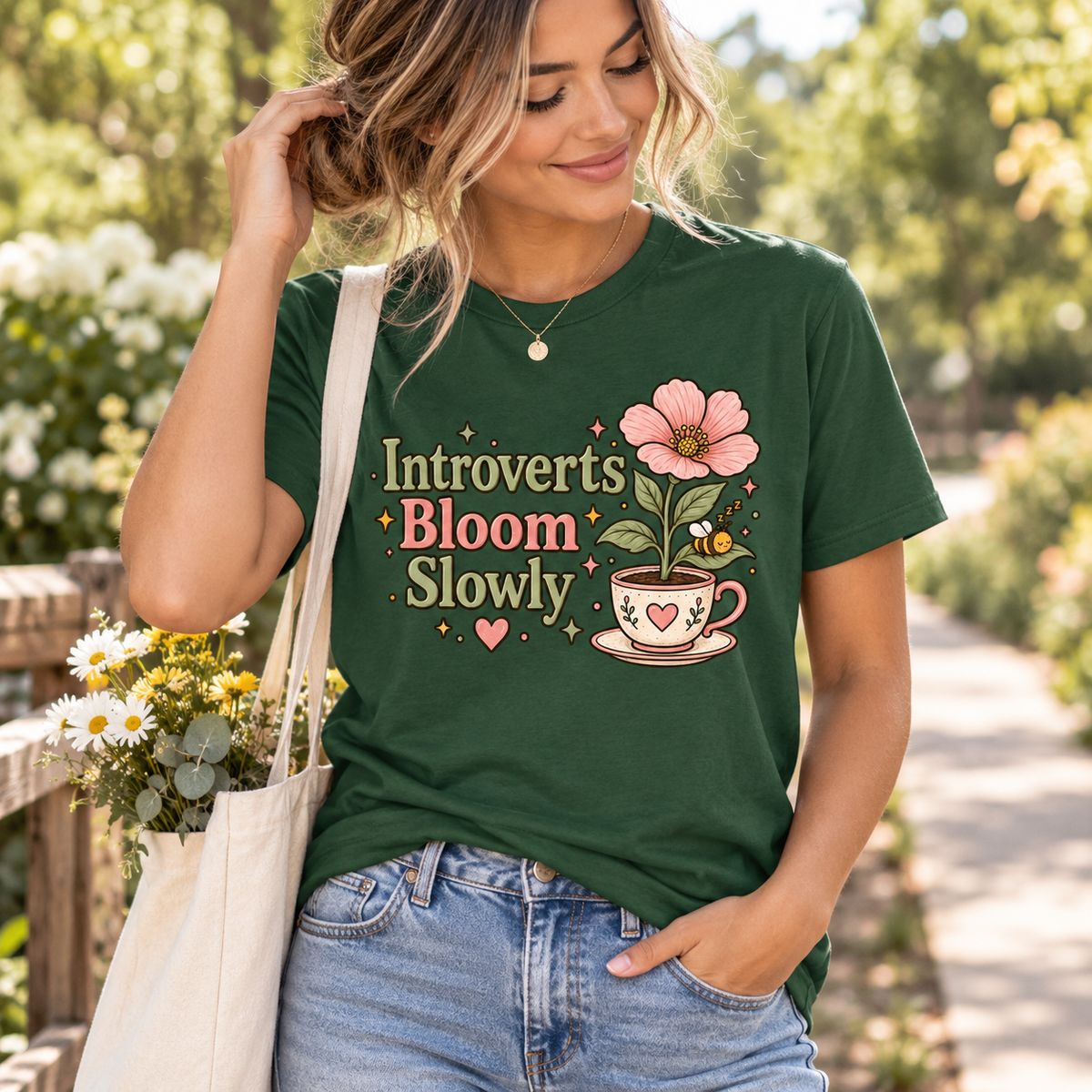 A woman wearing an evergreen Introverts Bloom Slowly cute plant graphic t-shirt.