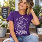 A woman wearing a team purple Planting my Peace cute plant graphic t-shirt.