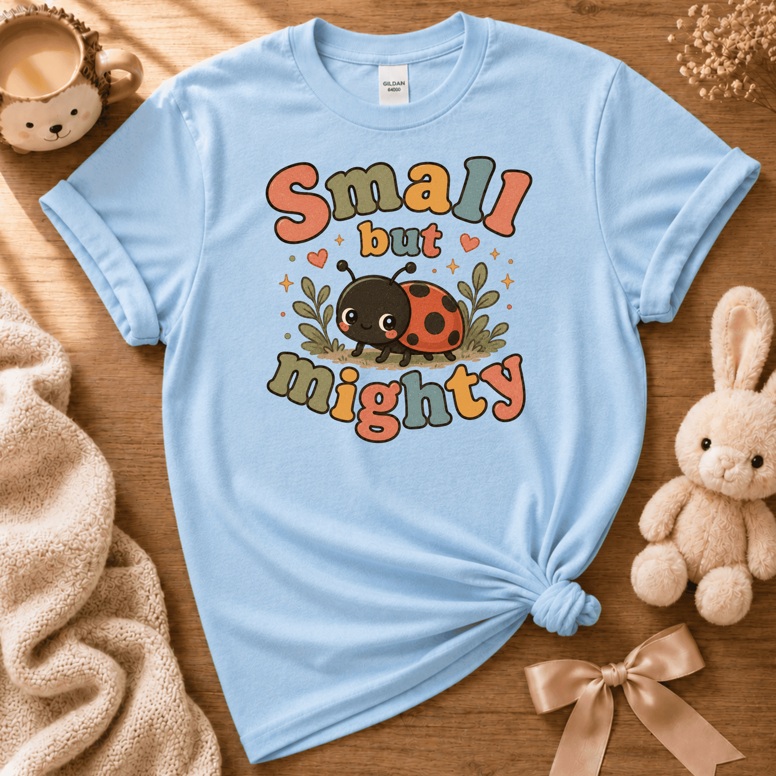 Small But Mighty cute animal graphic t-shirt cozy flat lay in light blue.