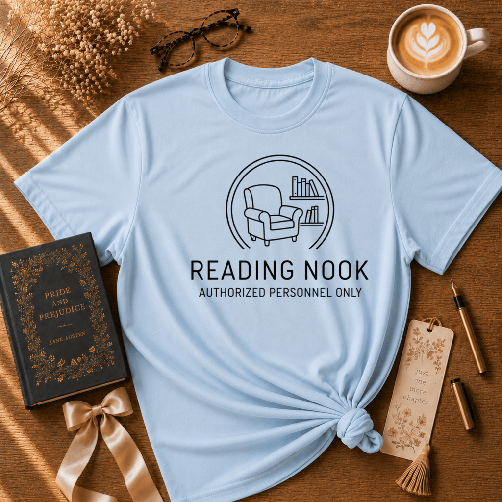 Reading Nook book graphic t-shirt displayed in a cozy flat lay in light blue.