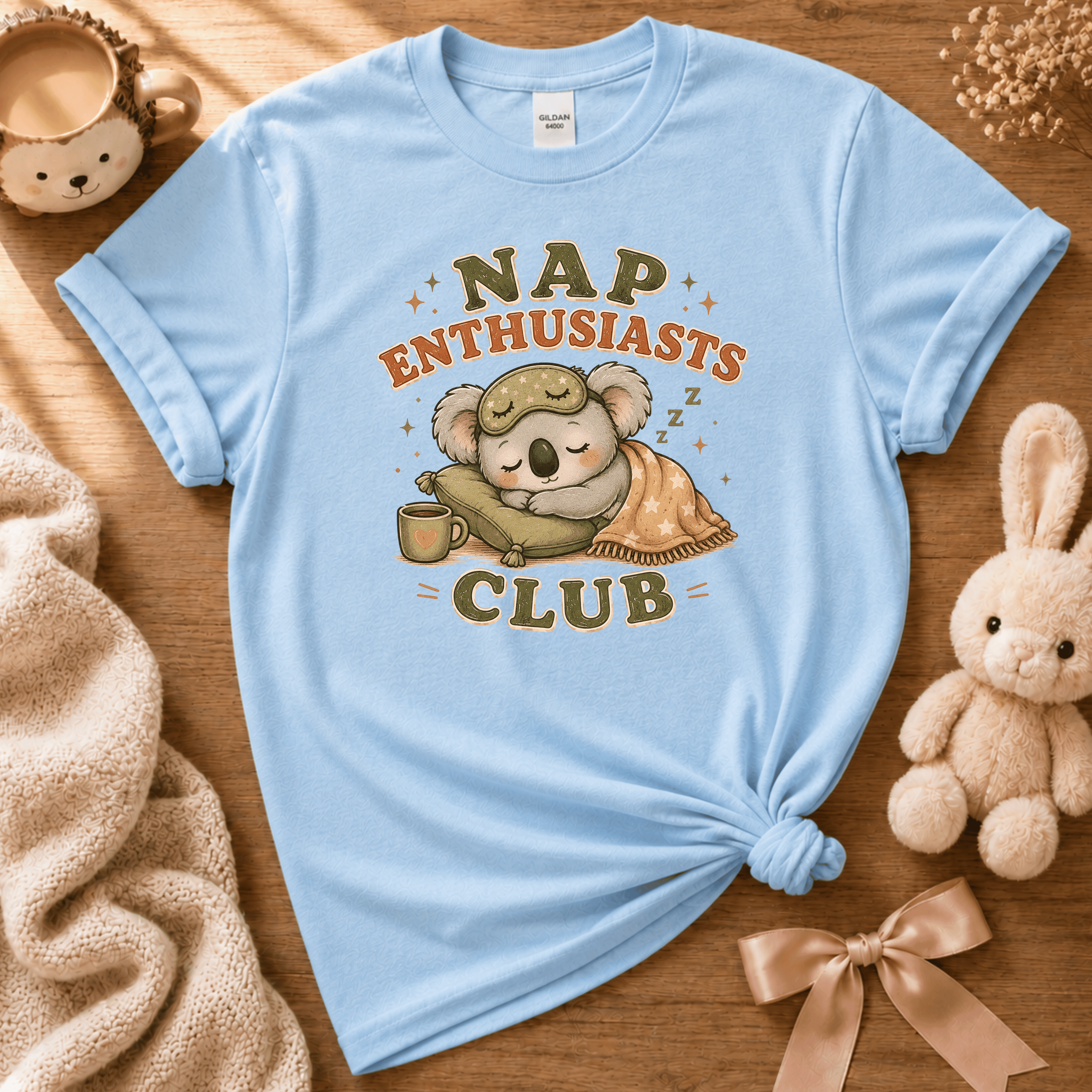 Nap Enthusiast Club cute animal graphic t-shirt cozy flat lay in light blue.