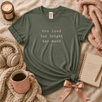 Too Much introvert graphic t-shirt cozy lay out in military green.