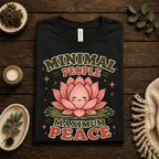 Minimal People Premium T-Shirt in vintage black, folded close-up styled with a candle and greenery
