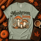 Mushroom Season Premium T-Shirt in sage, flat lay with illustrated mushrooms, ferns, and autumn props