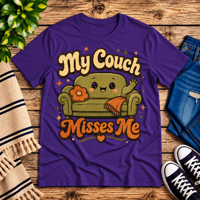 My Couch Misses Me Premium T-Shirt in team purple, flat lay with smiling cartoon couch graphic