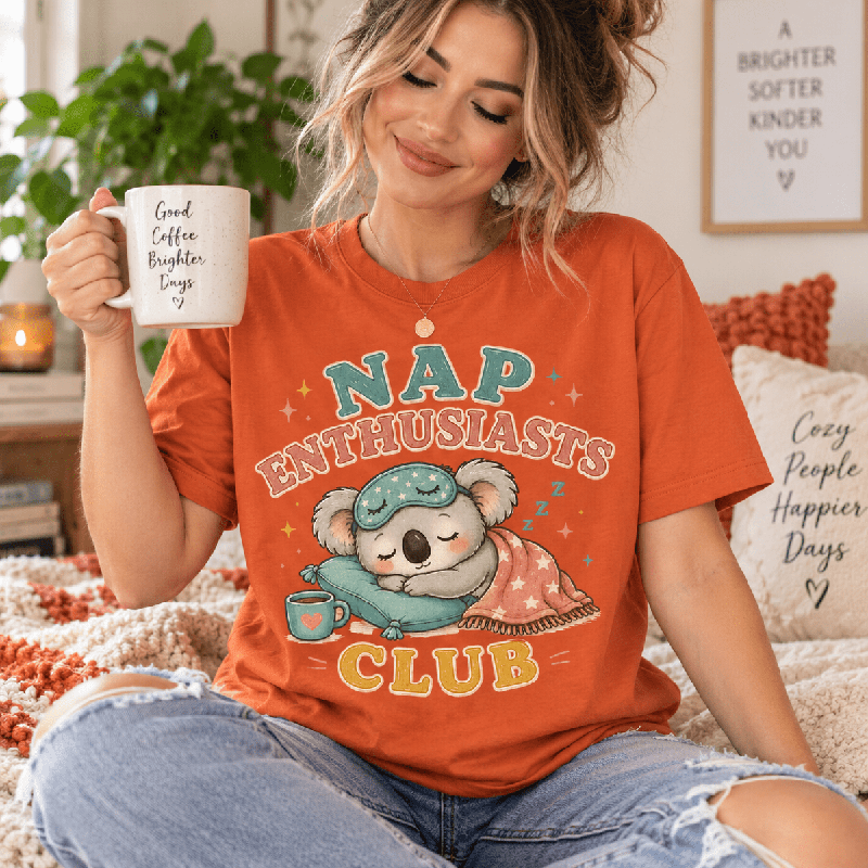 Woman holding a mug, wearing the Nap Enthusiasts Club Premium T-Shirt in burnt orange