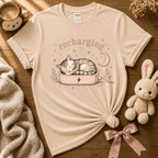 Recharging Cat cute animal graphic t-shirt cozy flat lay in natural.