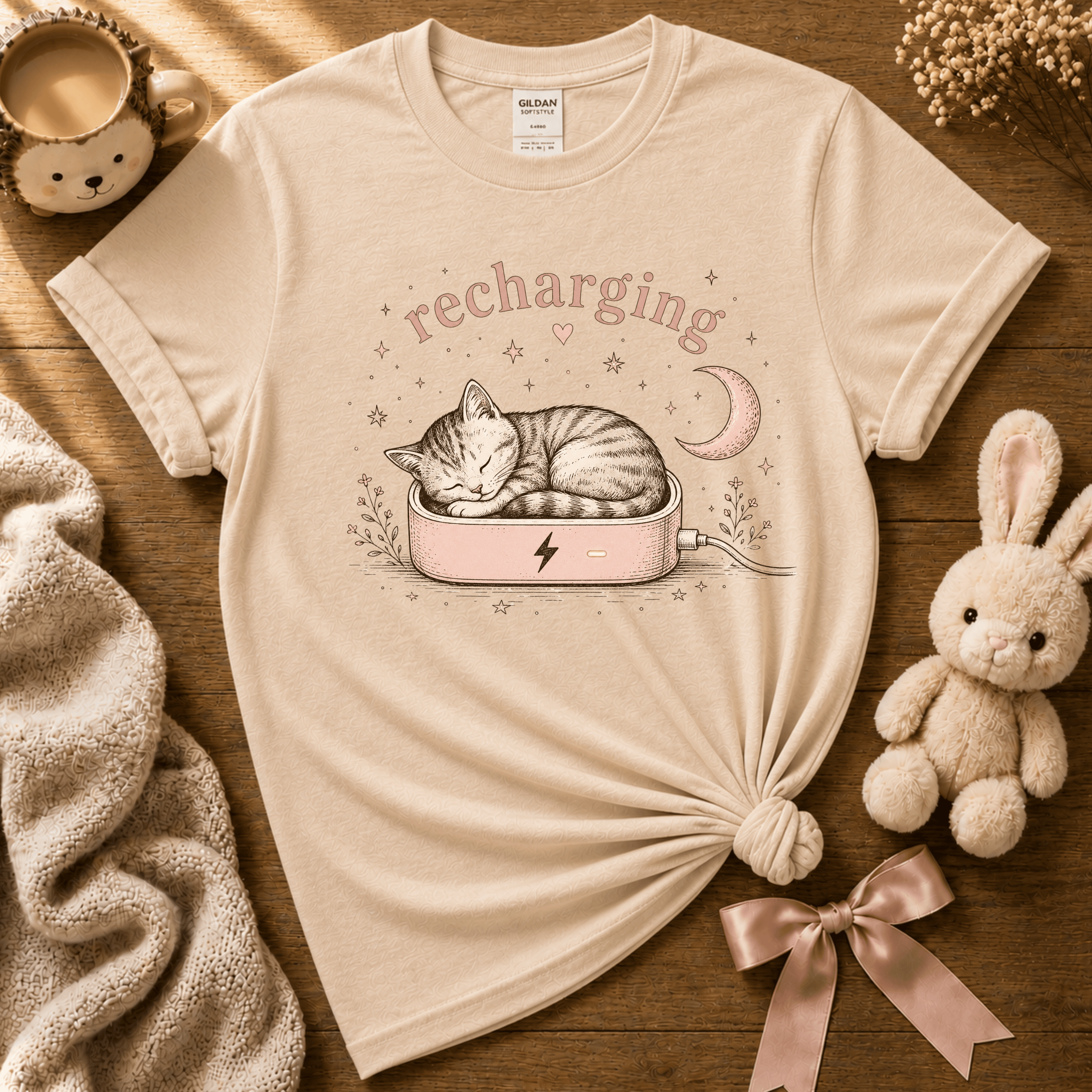 Recharging Cat cute animal graphic t-shirt cozy flat lay in natural.