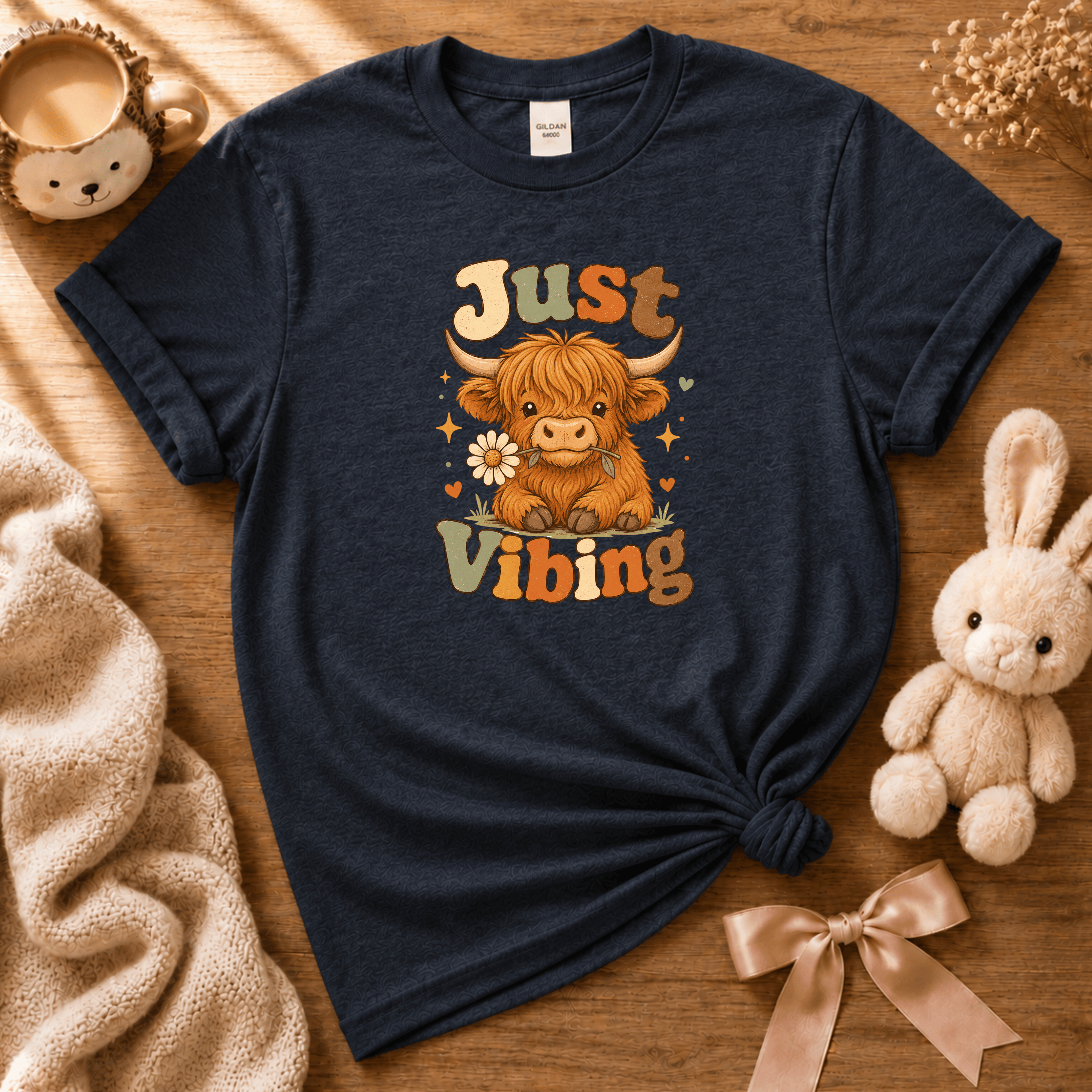 Just Vibing Cow cute animal graphic t-shirt displayed in a cozy flat lay in navy.