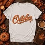 October Premium T-Shirt in vintage white, flat lay with "October" cursive script graphic and autumn props