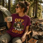 Woman holding a mug at a campsite, wearing the Off The Grid Nature Lover Premium T-Shirt in maroon