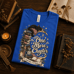One More Chapter Premium T-Shirt in true royal blue, folded close-up styled with vintage books and a candle