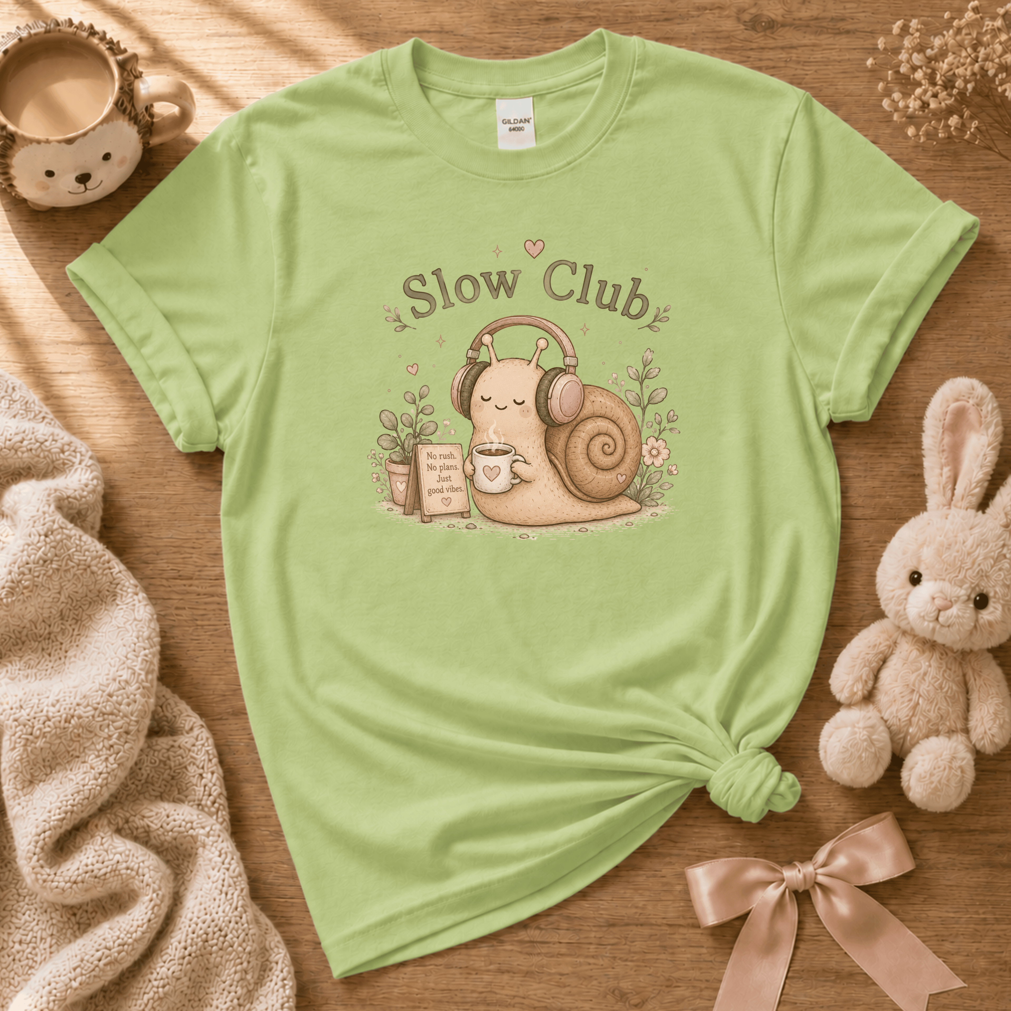 Slow Club cute animal graphic t-shirt displayed in a cozy flat lay in pistachio green.
