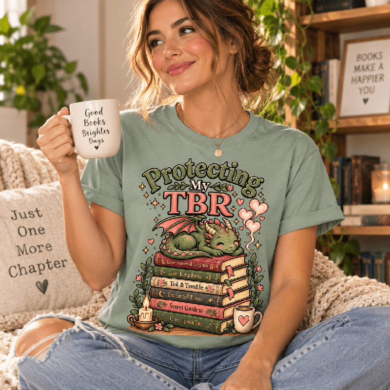 Woman holding a mug, wearing the Protecting My TBR Premium T-Shirt in sage
