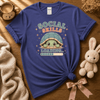 Social Skills cute animal graphic t-shirt displayed in a cozy flat lay in purple.