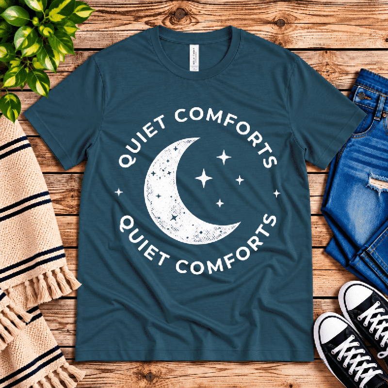 Quiet Comforts Light Premium T-Shirt in deep teal, flat lay with crescent moon and "Quiet Comforts" badge graphic