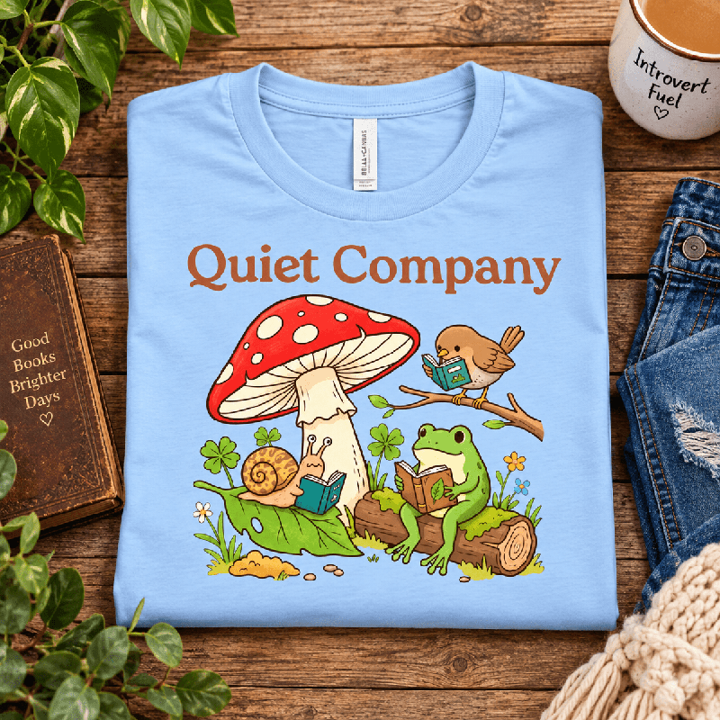 Quiet Company Premium T-Shirt in baby blue, folded close-up styled with a mug and book