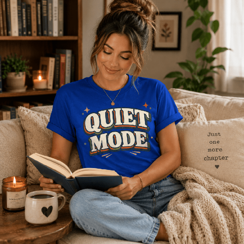 Woman reading a book on a couch, wearing the Quiet Mode Premium T-Shirt in true royal blue