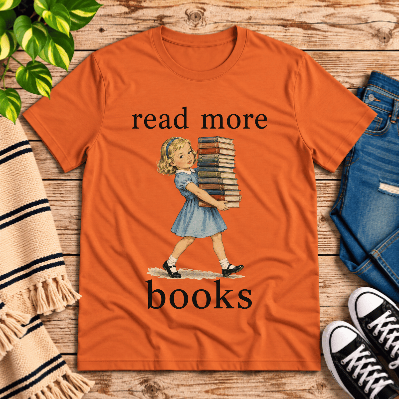 Read More Premium T-Shirt in burnt orange, flat lay with vintage girl carrying a stack of books graphic