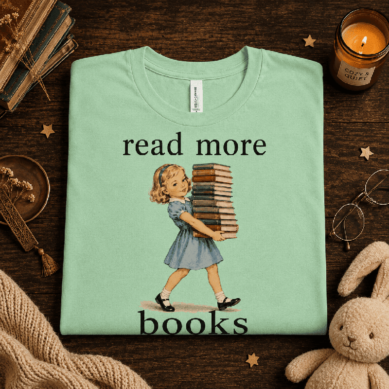 Read More Premium T-Shirt in mint, folded close-up styled with a stuffed bunny and books