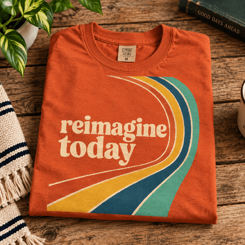 Reimagine Today Premium T-Shirt in burnt orange, folded close-up with neck tag showing