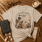 Imaginary People book graphic t-shirt displayed in a cozy flat lay in sand.