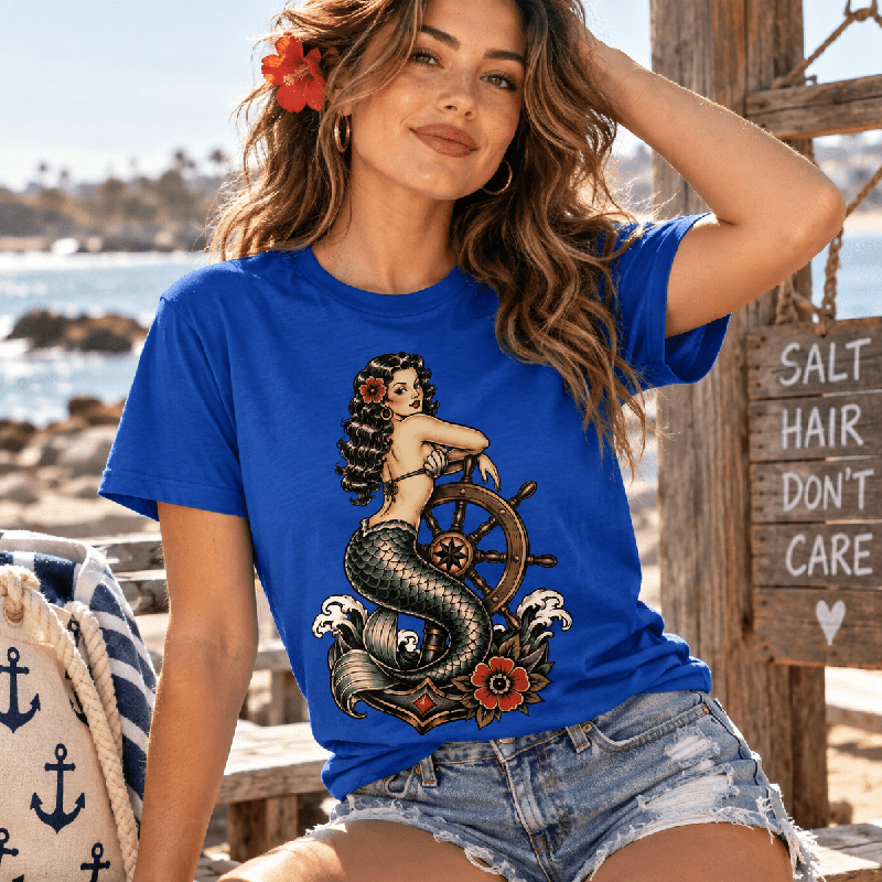 Woman wearing the Ship Wheel Mermaid Premium T-Shirt in true royal blue near a dock