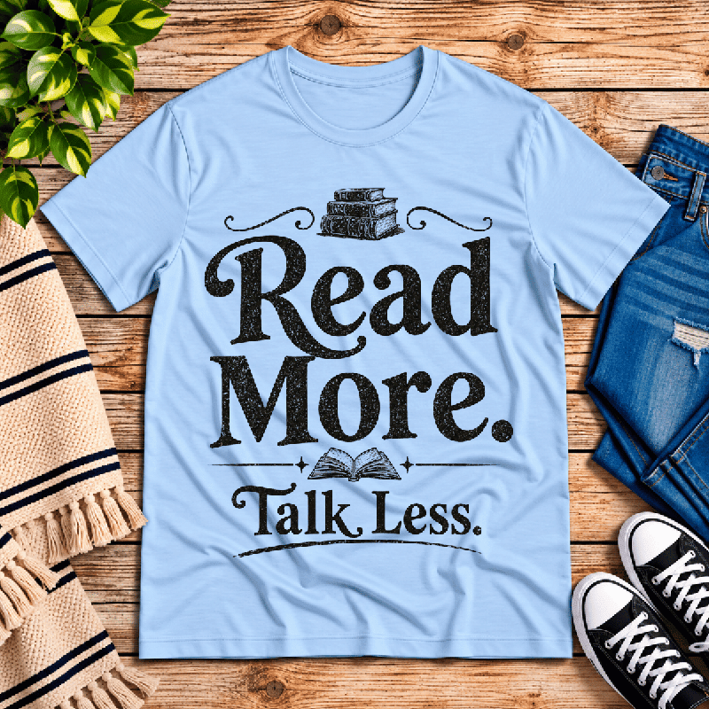 Talk Less Premium T-Shirt in baby blue, flat lay with "Read More. Talk Less." stacked books graphic