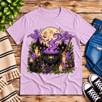 The Cauldron Premium T-Shirt in lilac, flat lay with black cat beside a bubbling cauldron graphic