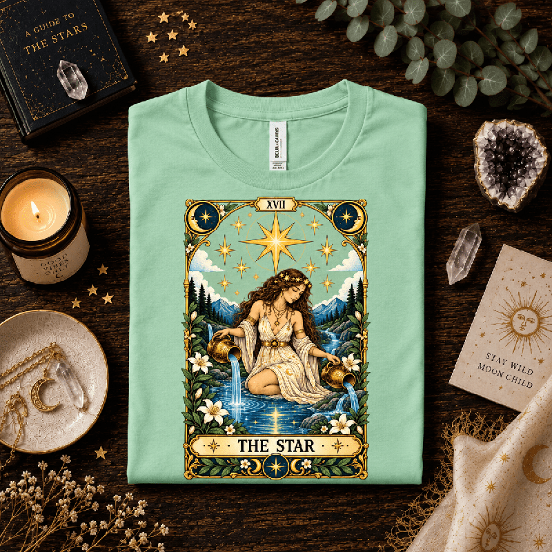 The Star Premium T-Shirt in mint, folded close-up styled with candle and crystals
