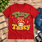 Tiny But Tasty Premium T-Shirt in red, flat lay with smiling polka-dot mushroom character graphic