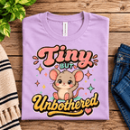 Tiny But Unbothered Premium T-Shirt in lilac, folded close-up with neck tag showing