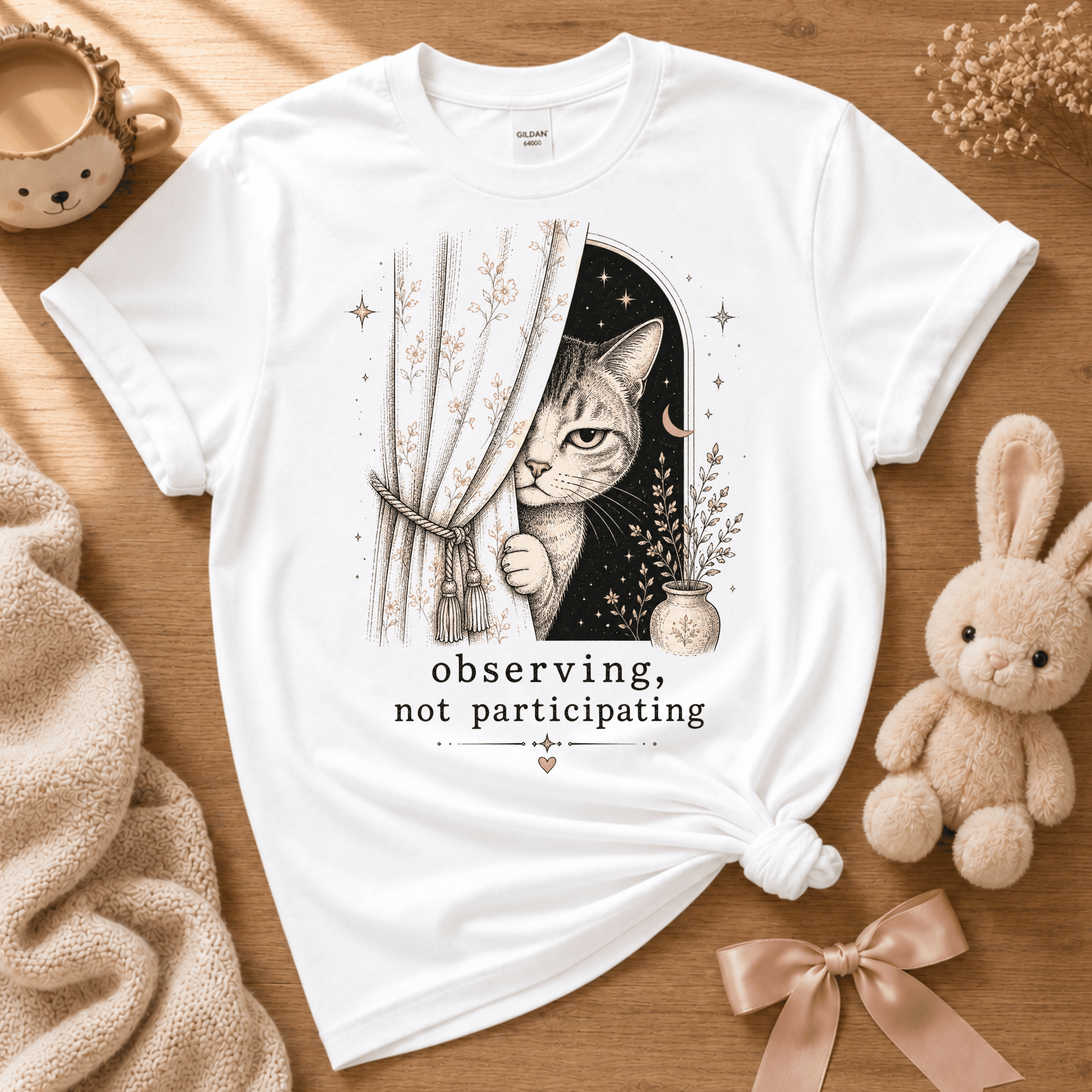 Observing cute animal graphic t-shirt displayed in a cozy flat lay in white.