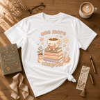 One More Chapter book lover graphic t-shirt displayed in a cozy flat lay in white.