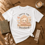 Sorry I'm Booked book lover graphic t-shirt flat lay in white.